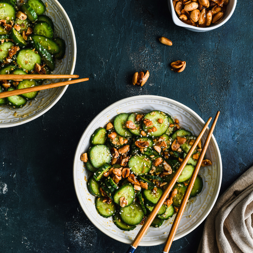 bowl of asian cucumber salad with wooden chopsticks sitting on top