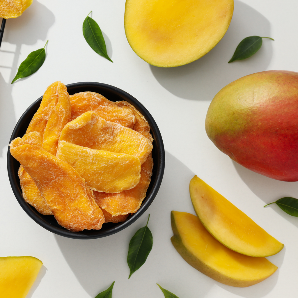 Dried and fresh mango pieces arranged on a white surface.