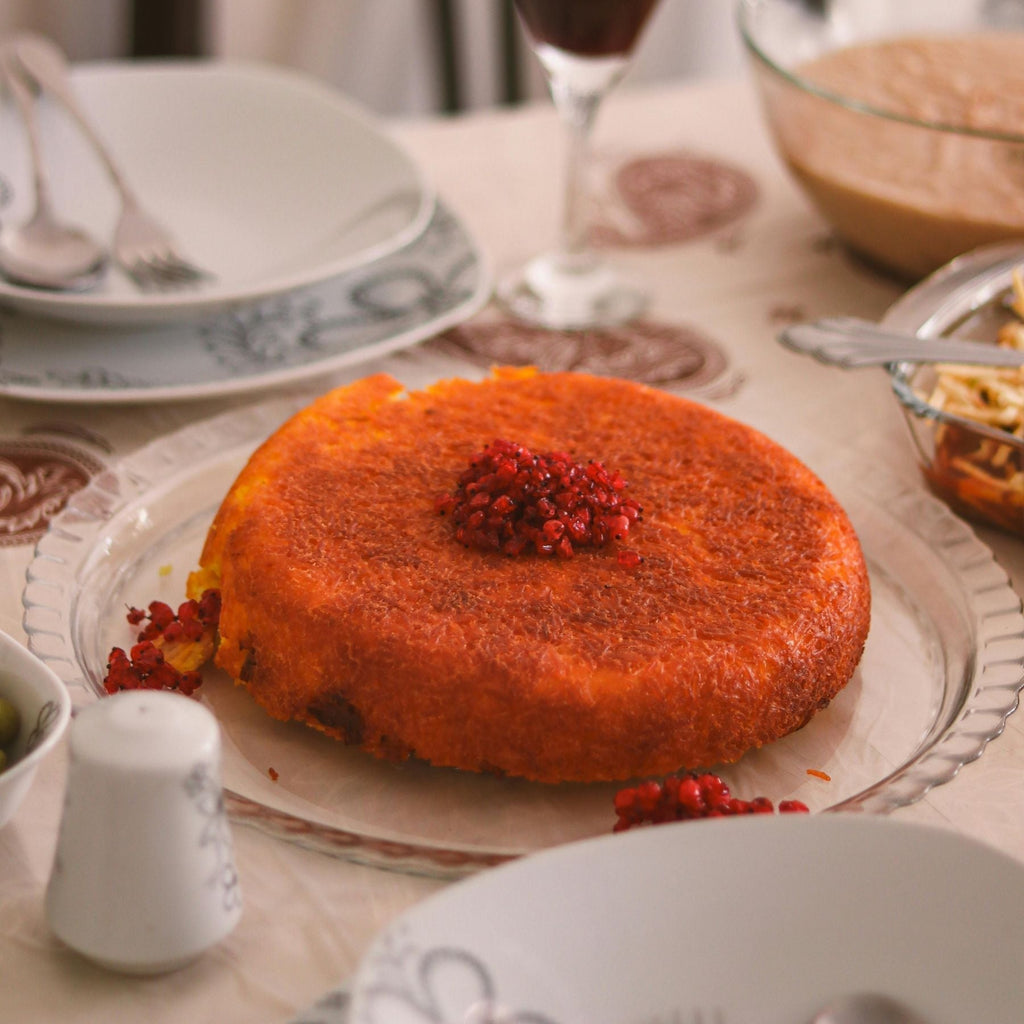 Saffron rice cake, known as tahchin, garnished with red barberries.