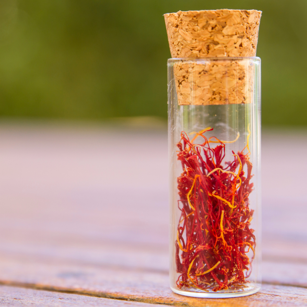 A glass jar filled with dried saffron, a vibrant and aromatic spice used in cooking and traditional medicine.