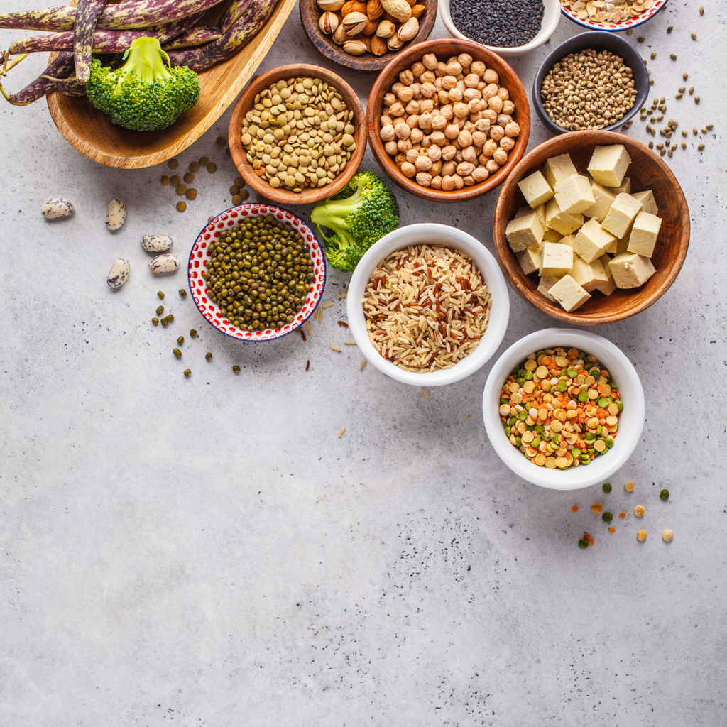Bowls containing foods that help boost estrogen such as chickpeas, legumes, broccoli and butter.