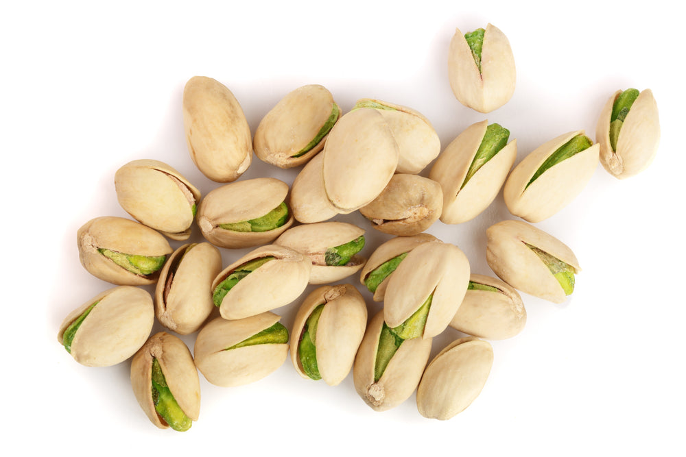 Raw pistachios in shell against a white background